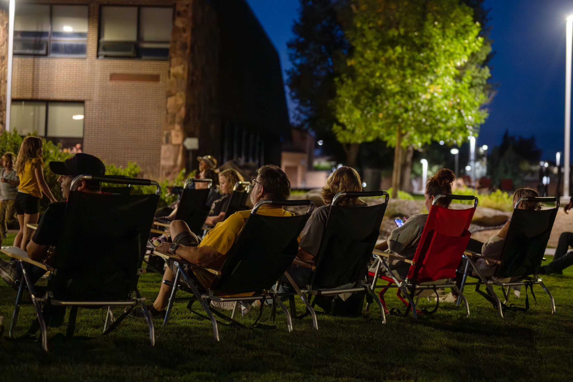 People sitting in lawn chairs listening to band play music