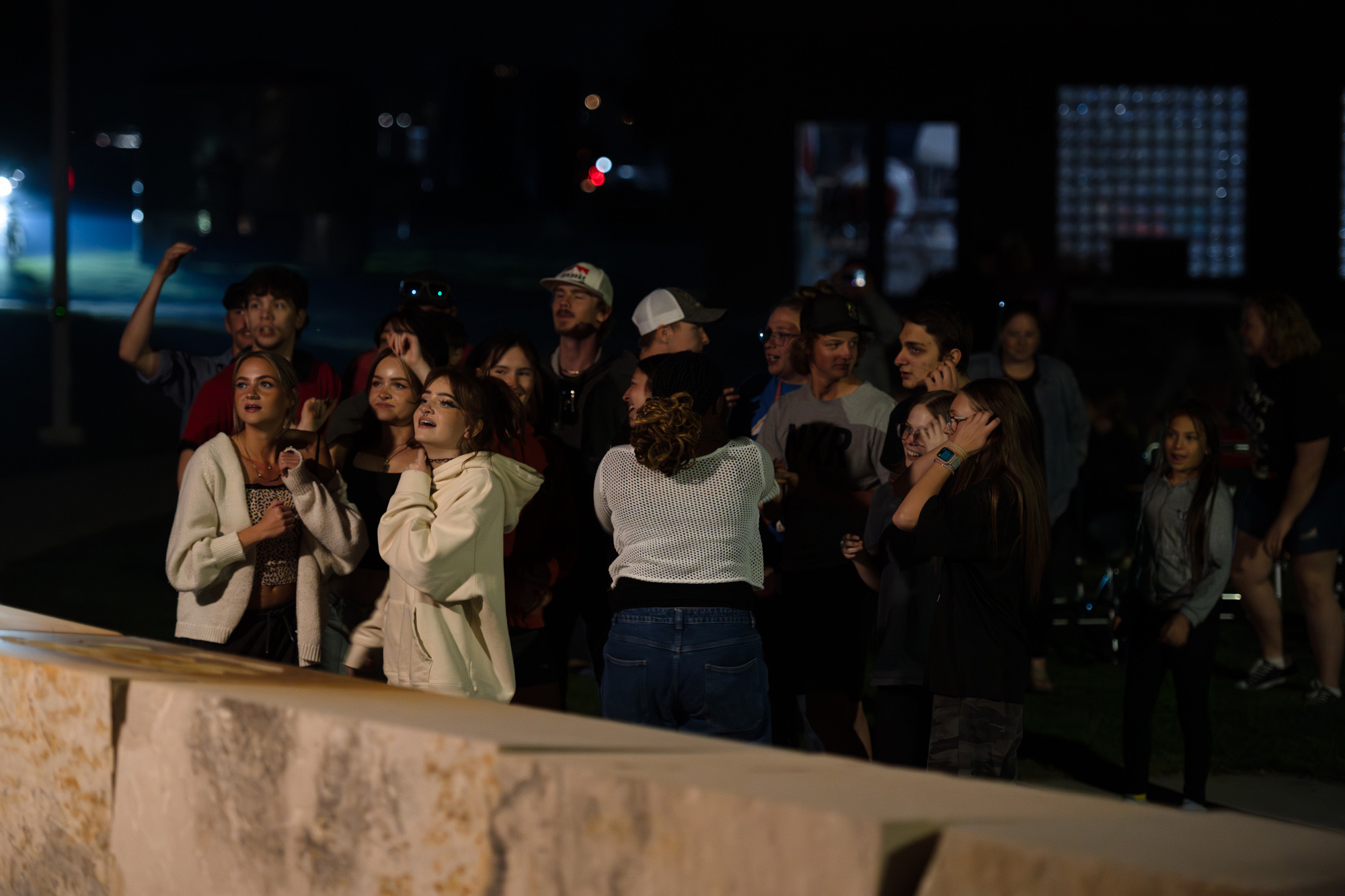 Students standing near stage listening to band play music