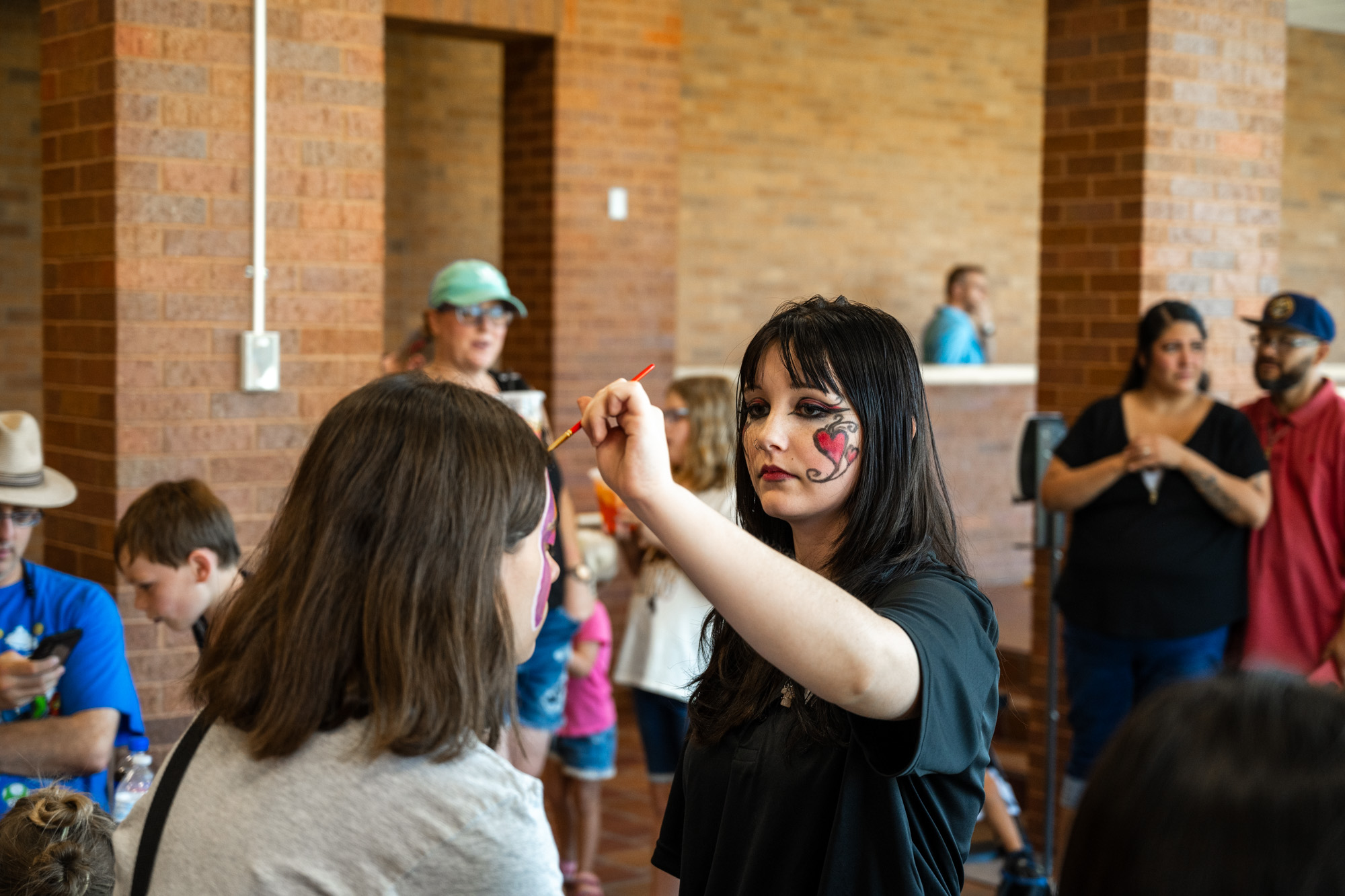 Theatre student painting the face of a girl.