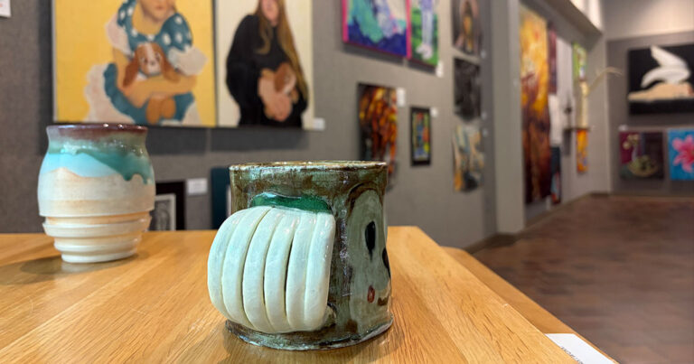 A ceramic vase with a white and green motif, emphasizing its intricate design and aesthetic charm