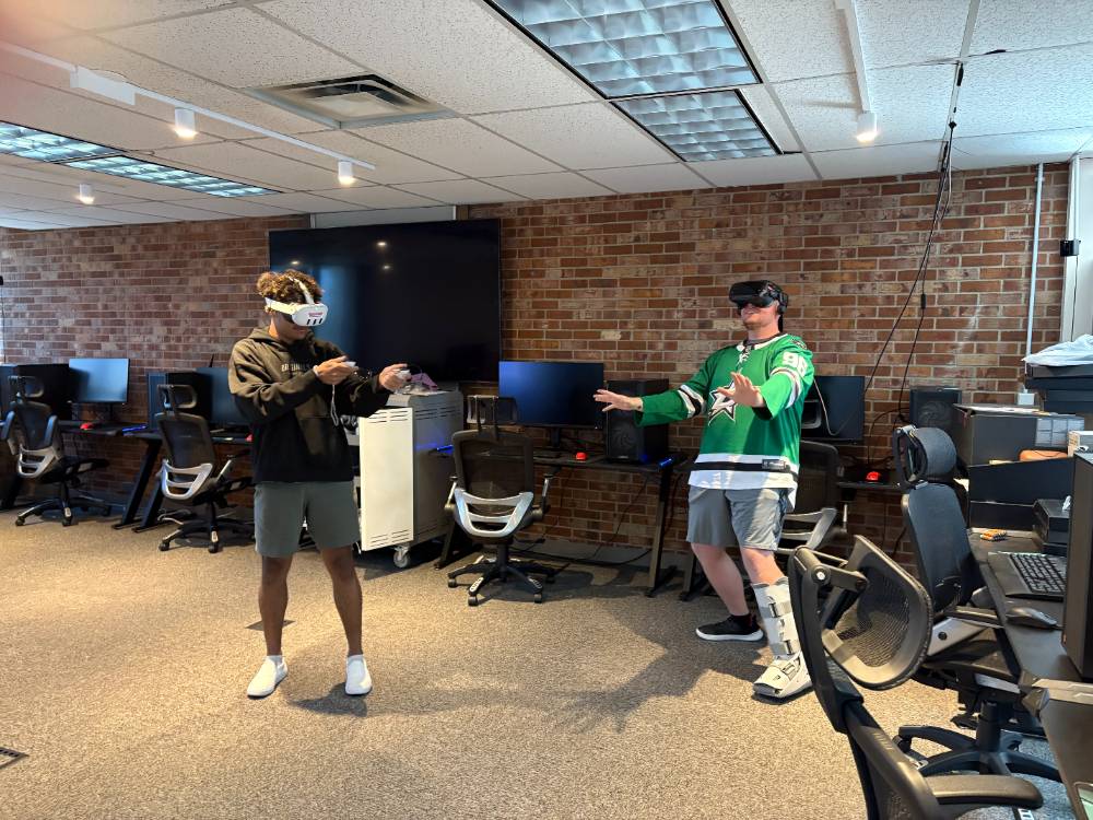 Two students, in VR headsets, in the VR lab