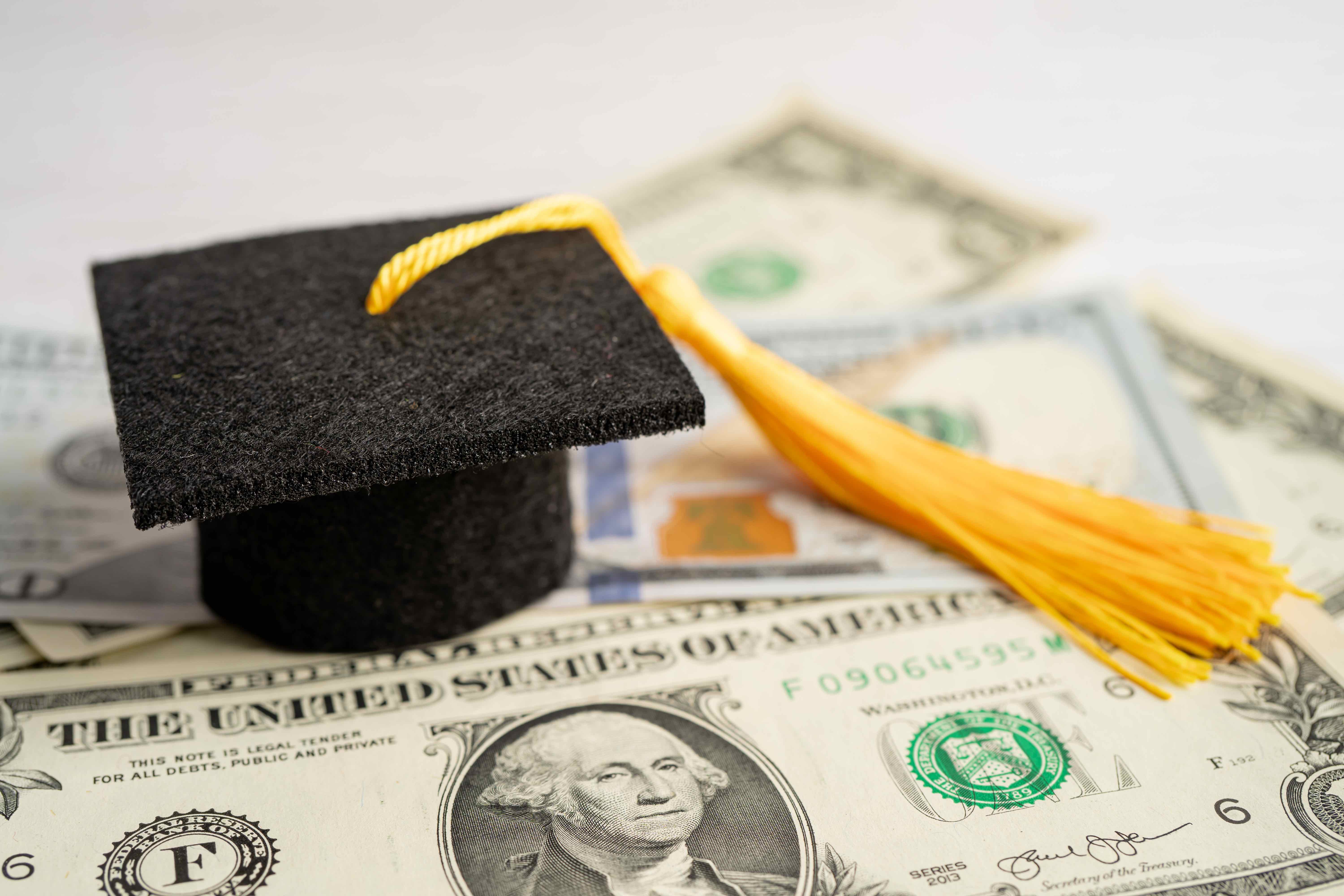 Graduation cap sitting on top of cash.