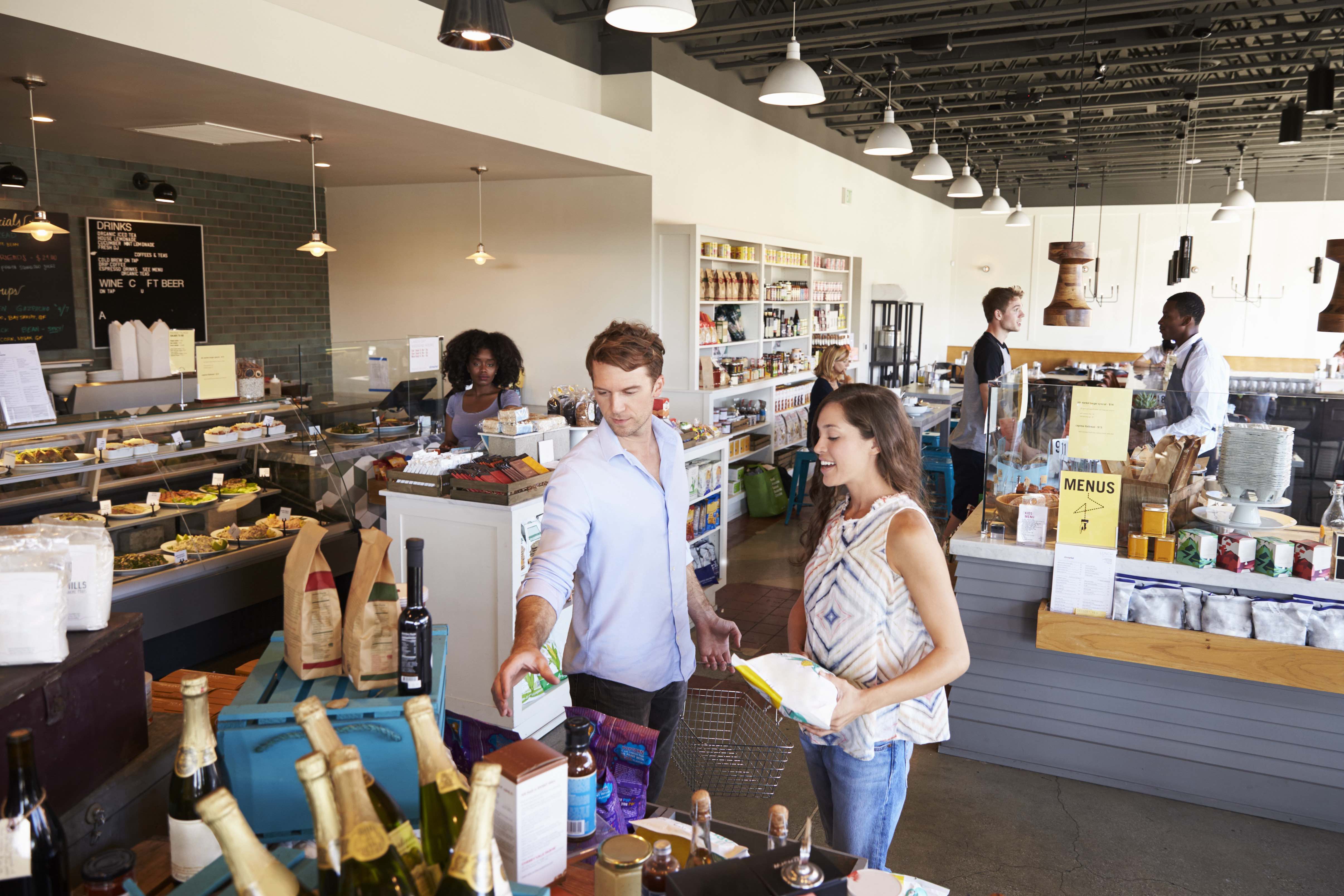 A man and women in a boutique grocery store. 