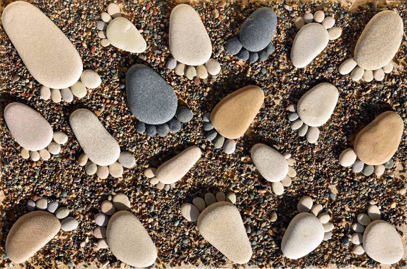 Pebble stones arranged like footprints on the beach