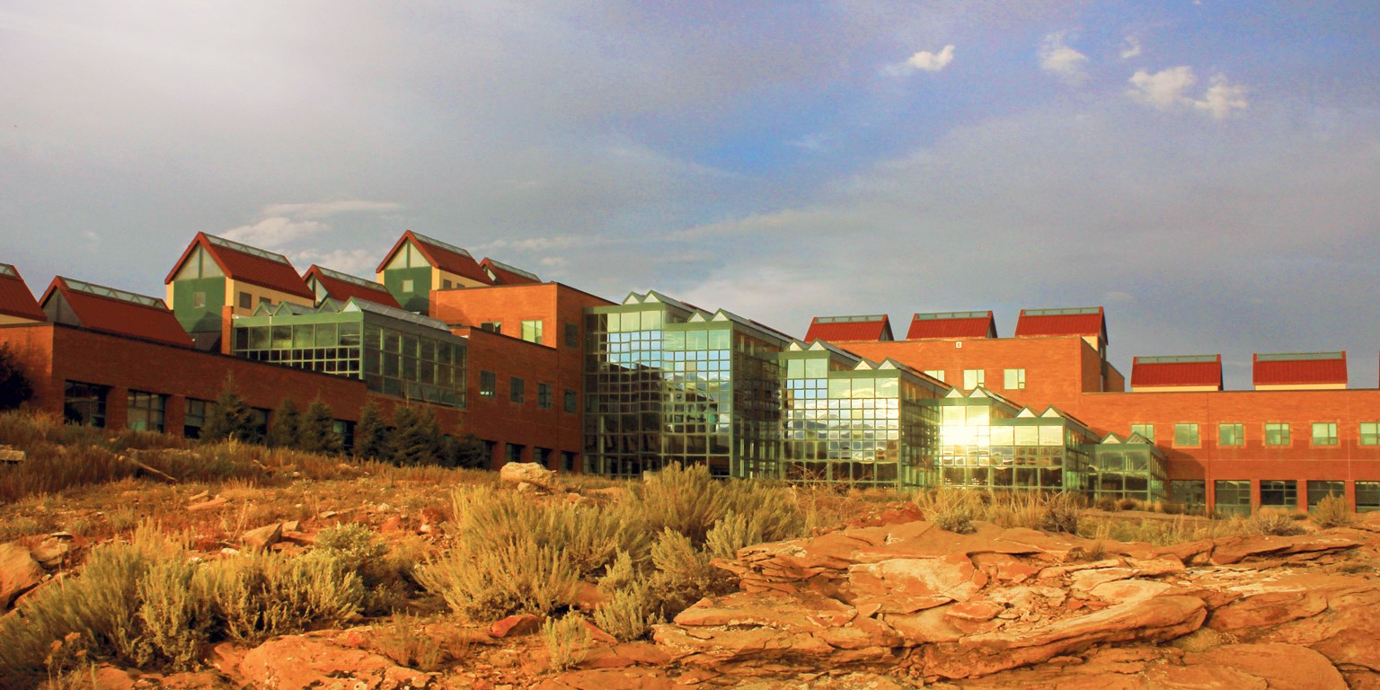 Photo of the campus facing the atrium from the outside at sunset. 