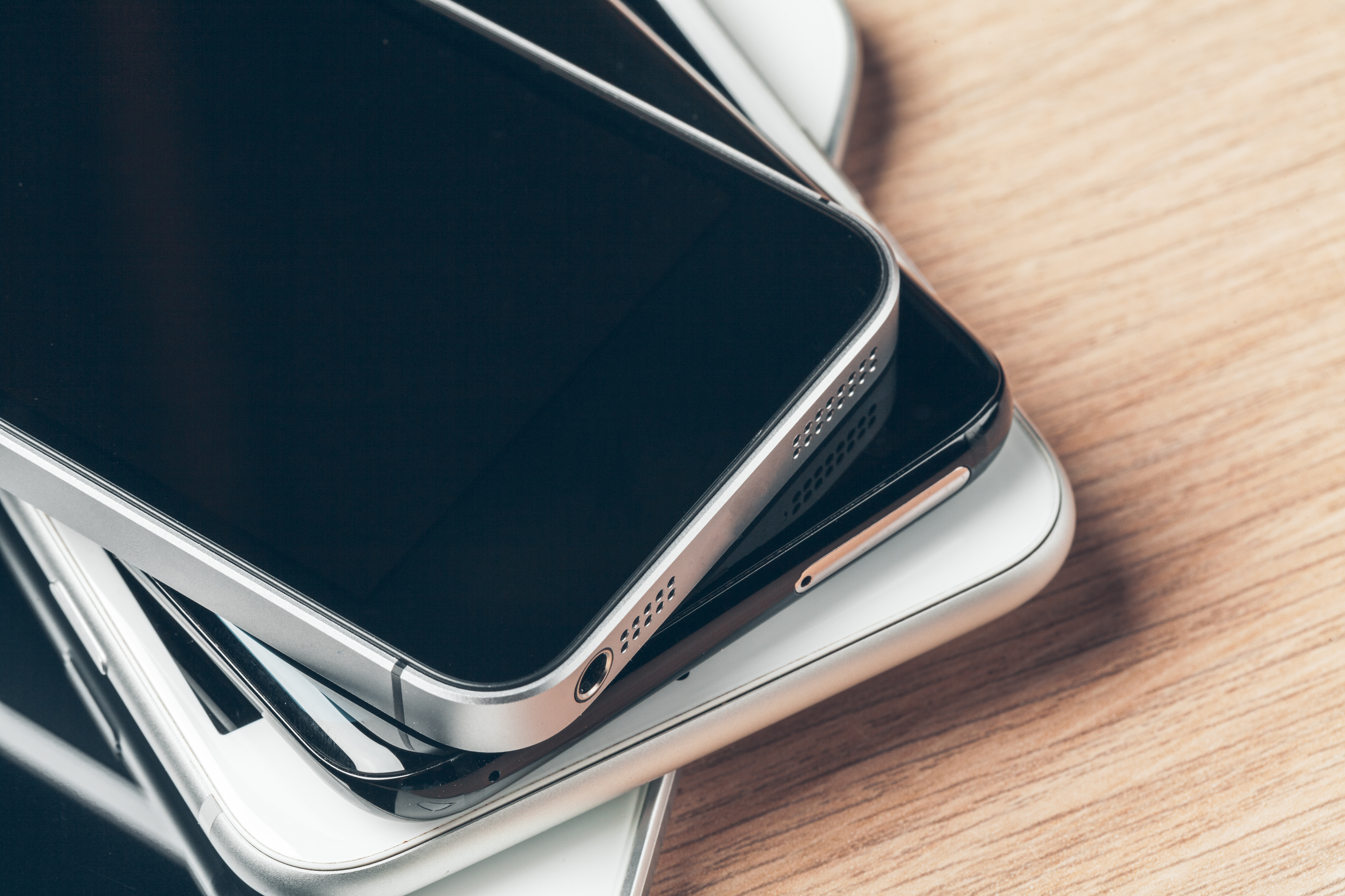 stack of mobile phones and digital tablets with blank screens