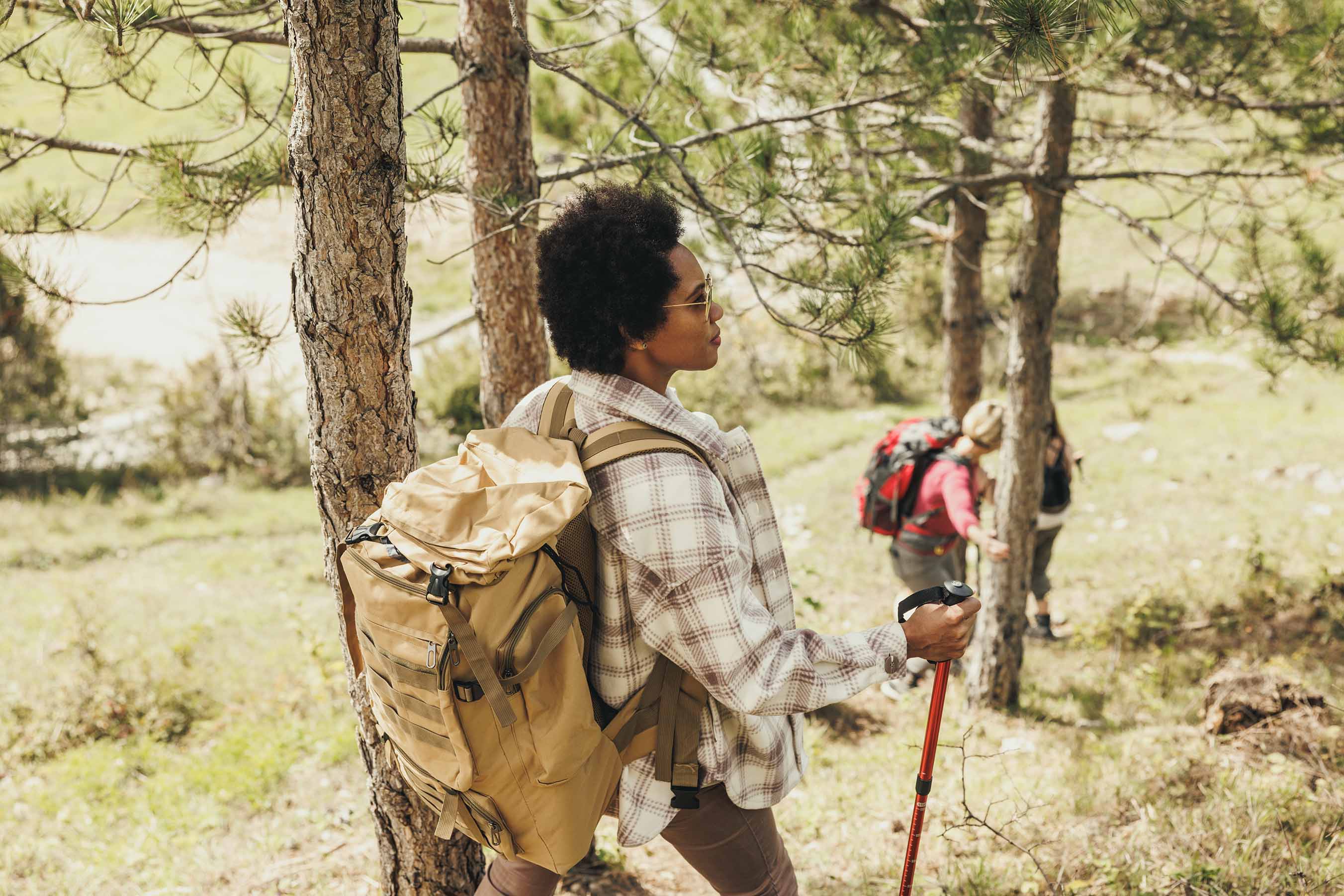 Woman hiking through forest wearing a backpack 