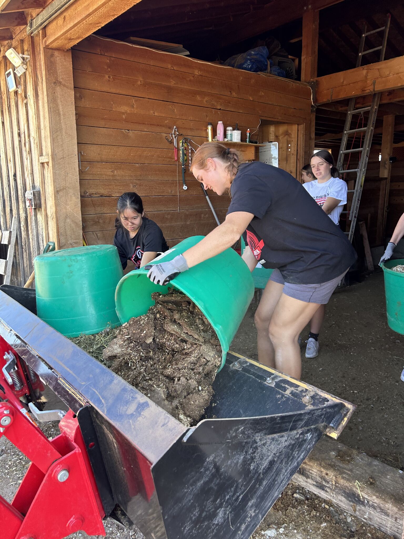 Women athlete dumping manure.